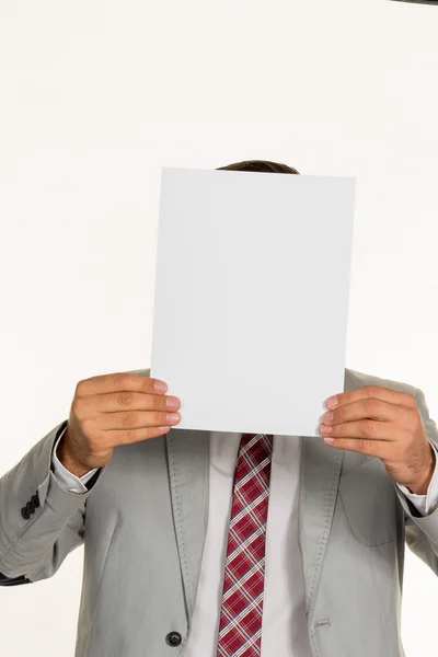 Manager holding blank sheet in front of face — Stock Photo, Image