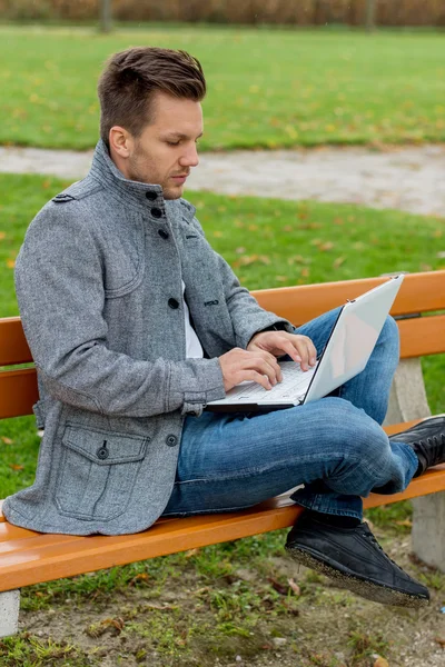 Man med laptop i parken — Stockfoto