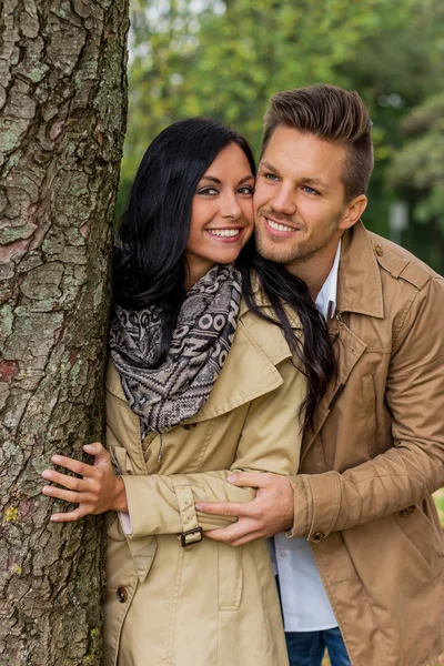 Enamoured couple behind a tree — Stock Photo, Image