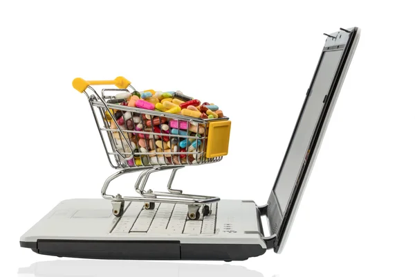 Tabletas con carrito de compras y computadora — Foto de Stock