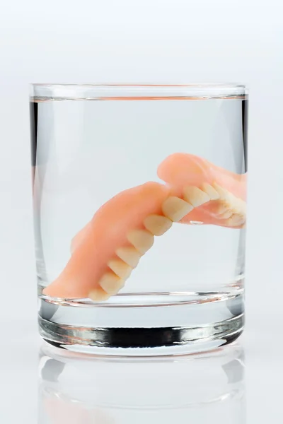 Зубные протезы в чашке — стоковое фото