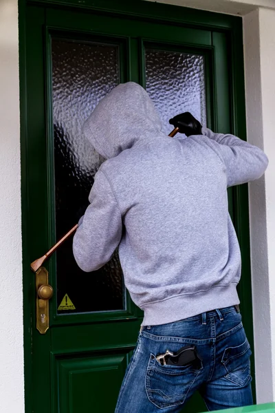 Assaltante em uma porta de casa — Fotografia de Stock