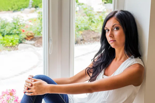 Mujer sentada en la ventana — Foto de Stock