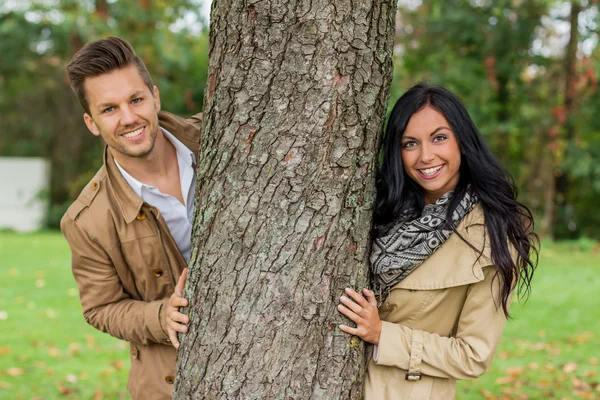 Casal apaixonado atrás de uma árvore — Fotografia de Stock