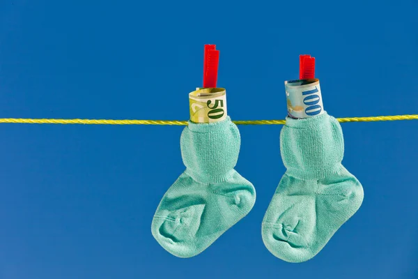 Baby socks on clothesline with swiss francs — Stock Photo, Image