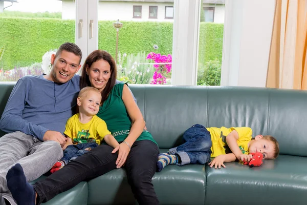 Familjen sitter på en soffa — Stockfoto