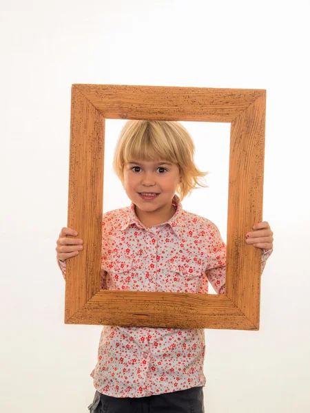 Niño mirando a través de un marco — Foto de Stock