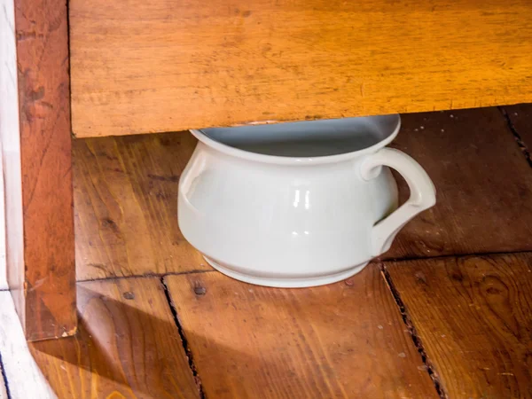 Chamber pot under a bed — Stock Photo, Image