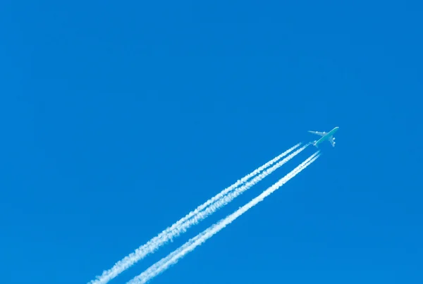 在空中有尾迹的飞机 — 图库照片