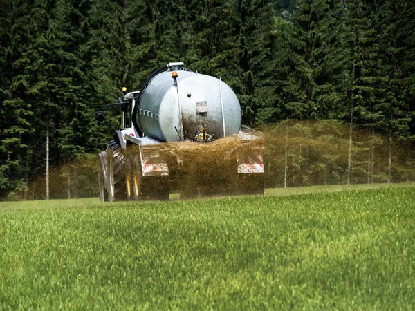 Farmer fertilizes a field with manure — Stock Photo, Image