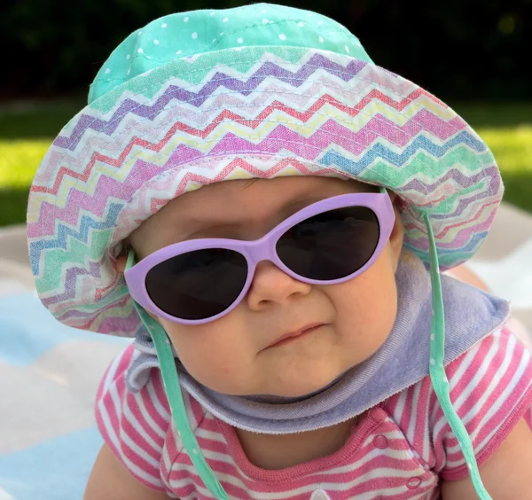 Baby with sun hat and sunglasses in the garden — Stock Photo, Image