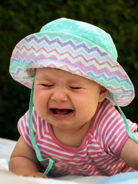 Baby lying on a lawn and crying — Stock Photo, Image