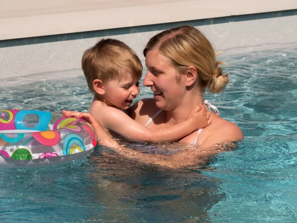 Niño con anillo flotante se enfría en la piscina en el día caliente en el — Foto de Stock