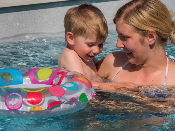 Niño con anillo flotante se enfría en la piscina en el día caliente en el — Foto de Stock