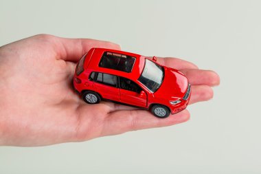 hand holding model of a car clipart
