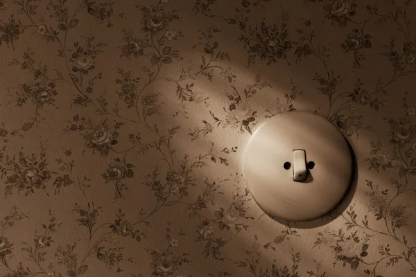 Old wallpaper with light switch — Stock Photo, Image