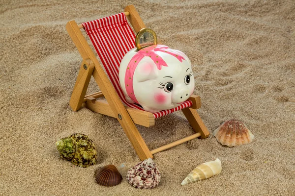 Deck chair with piggy bank and euro — Stock Photo, Image