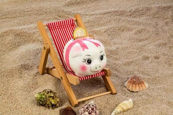 Beach chair with piggy bank and euro — Stock Photo, Image