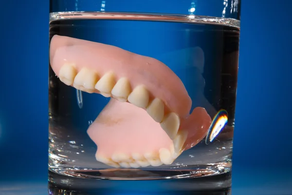 Denture in water glass — Stock Photo, Image