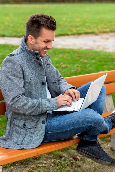 Man met laptop in het park — Stockfoto