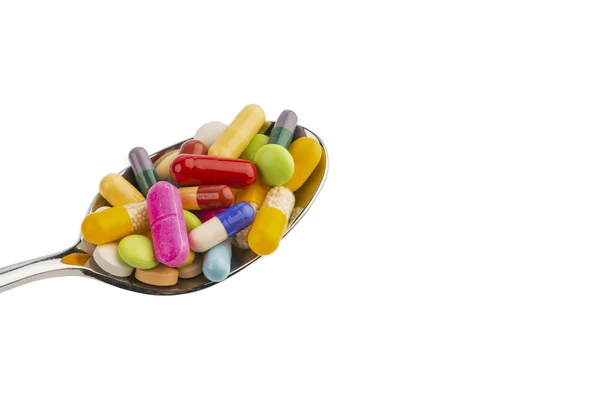 Viele Tabletten auf Löffel — Stockfoto