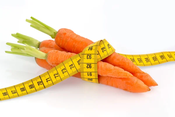 Fresh carrots with tape measure — Stock Photo, Image