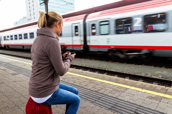 Žena čekala na vlak a píše sms — Stock fotografie