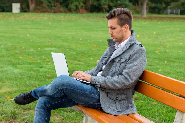 Man met laptop in het park — Stockfoto