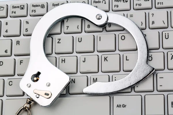 Handcuffs on computer keyboard — Stock Photo, Image