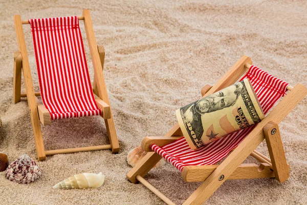 Beach chair with piggy bank and dollars — Stock Photo, Image