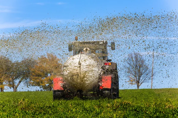 Traktor termékenyít a trágya mező — Stock Fotó