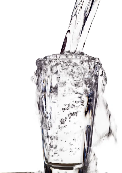 A água é derramada em um copo de água — Fotografia de Stock