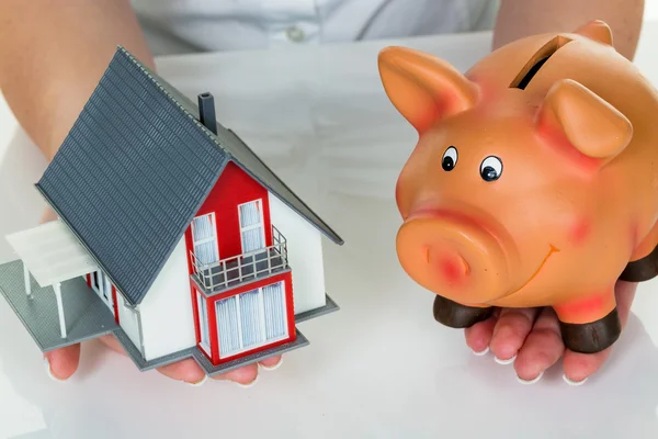 Woman with house and piggy bank — Stock Photo, Image