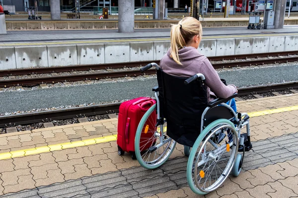 Kobieta siedzi na wózku inwalidzkim na dworzec kolejowy — Zdjęcie stockowe