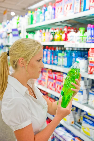 Mujer comprando productos de limpieza en un supermercado — Foto de Stock