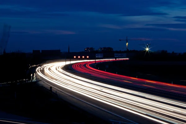 Автомобили на автостраде ночью — стоковое фото