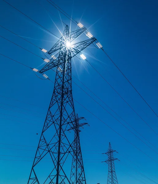 Pilão de eletricidade contra a luz — Fotografia de Stock