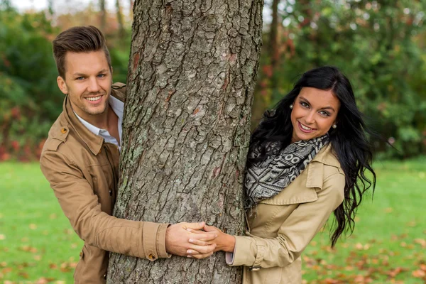 Courting couple behind a tree — Stock Photo, Image