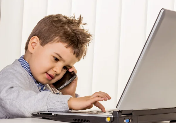 Kleine jongen op een laptop — Stockfoto