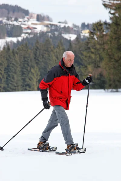 Senior snowshoeing in winter — Stock Photo, Image