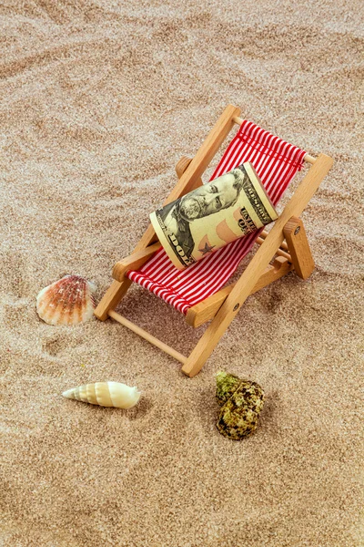 Beach chair with piggy bank and dollars — Stock Photo, Image