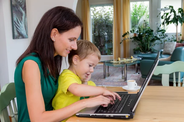 Kvinna med laptop och barn — Stockfoto