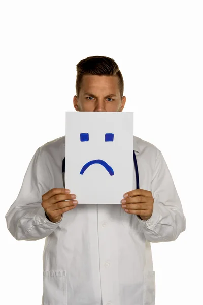 Doctor holding negative smiley face before — Stock Photo, Image