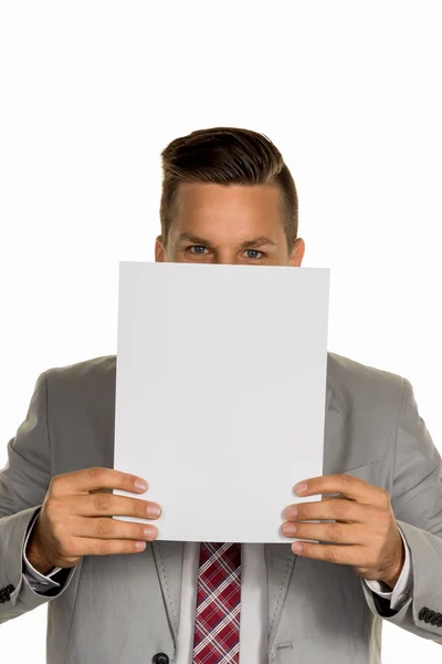 Manager holding blank sheet in front of face — Stock Photo, Image