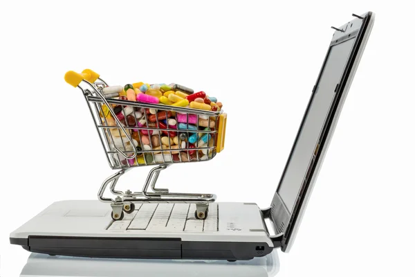 Comprimidos com carrinho de compras e computador — Fotografia de Stock