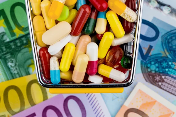 Tabletki, koszyk, rachunki euro — Zdjęcie stockowe