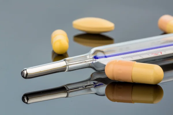 Thermometer and tablets — Stock Photo, Image