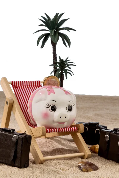 Piggy bank in a deck chair — Stock Photo, Image