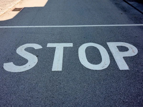 Stop inscripción en un camino — Foto de Stock