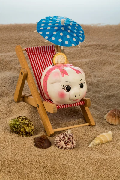 Strandstoel met piggy bank en de euro — Stockfoto